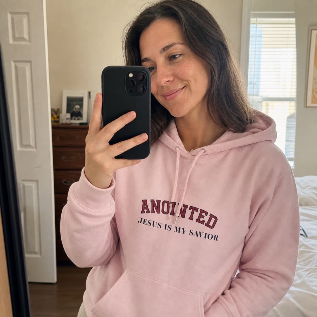 Customer mirror selfie wearing the light pink My Jesus hoodie